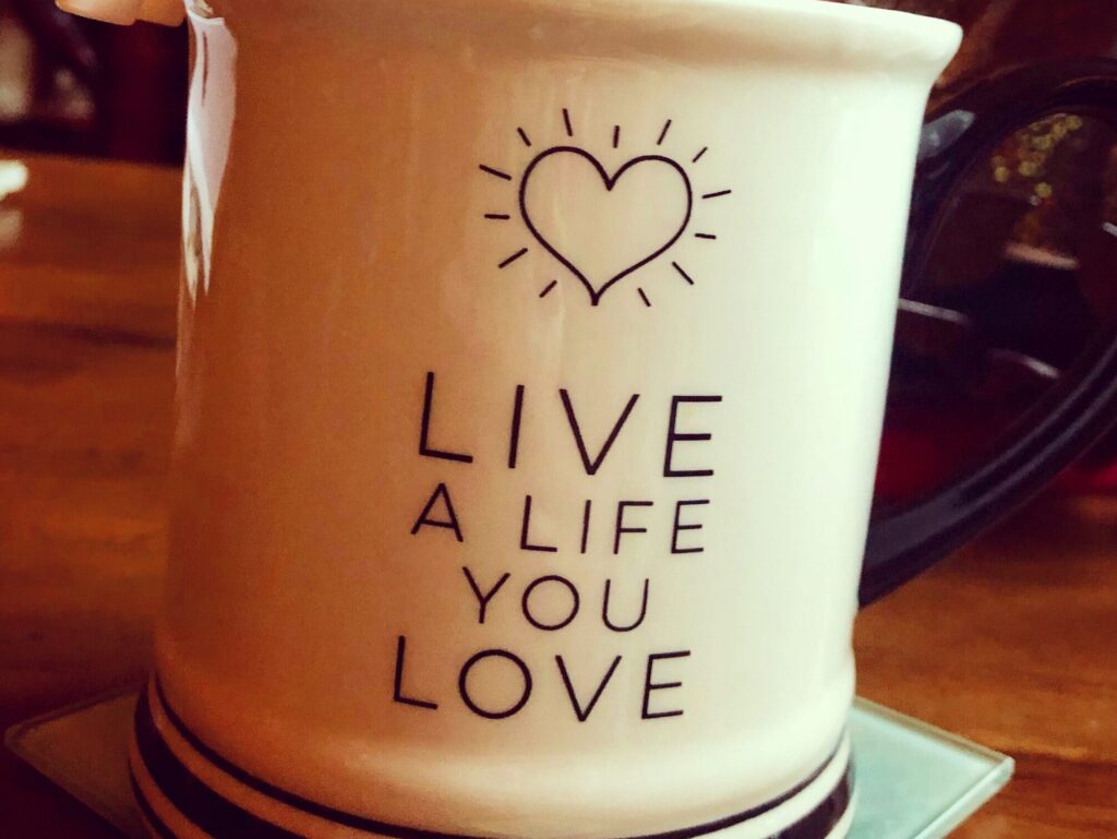 A white mug which says Live A Life You Love